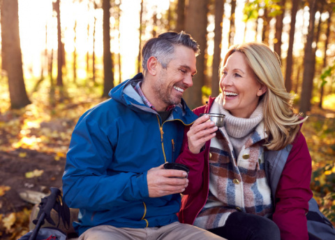 Mature Retired Couple Stop for Rest and Hot Drink on Walk Through Fall Countryside